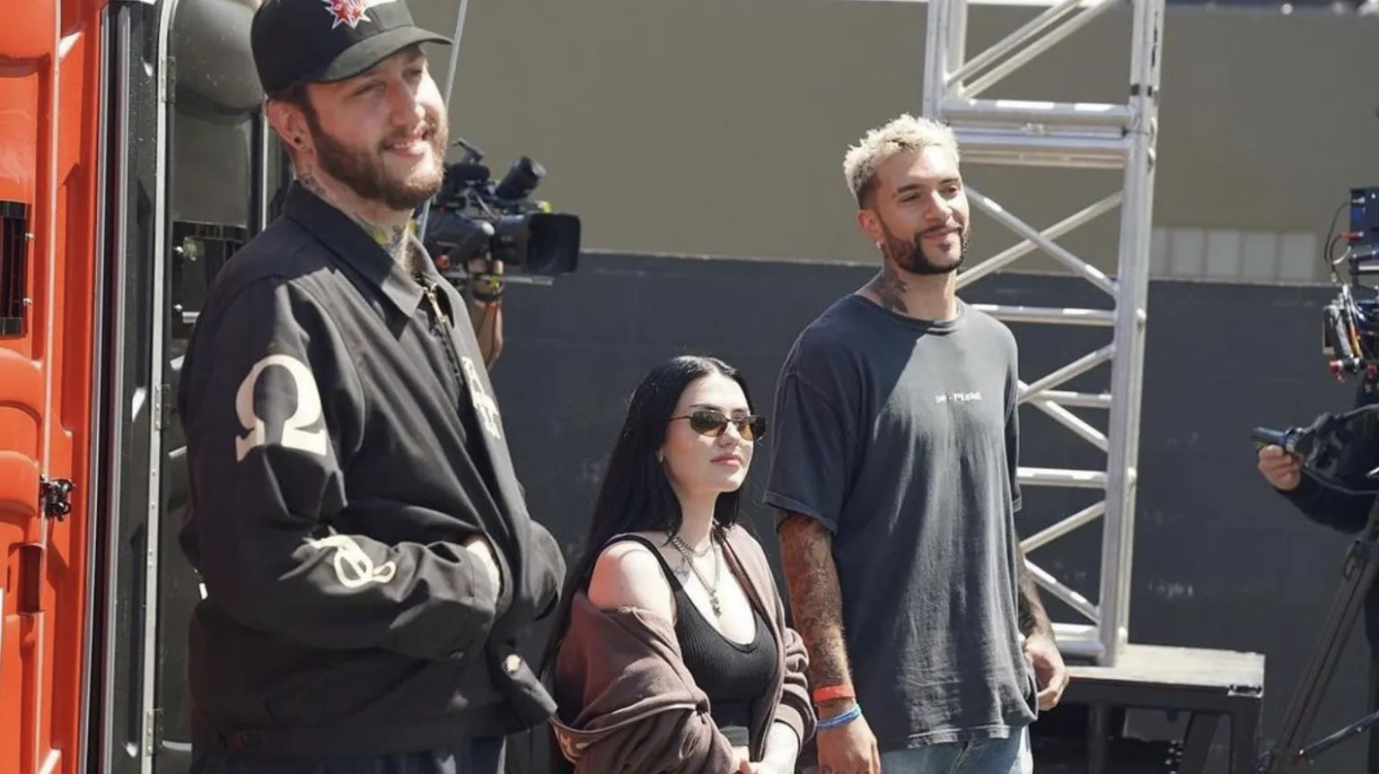 Fotografía de Banks, Kalei y Temperr.  Están entre bastidores en un set de filmación, vestidos completamente de negro.